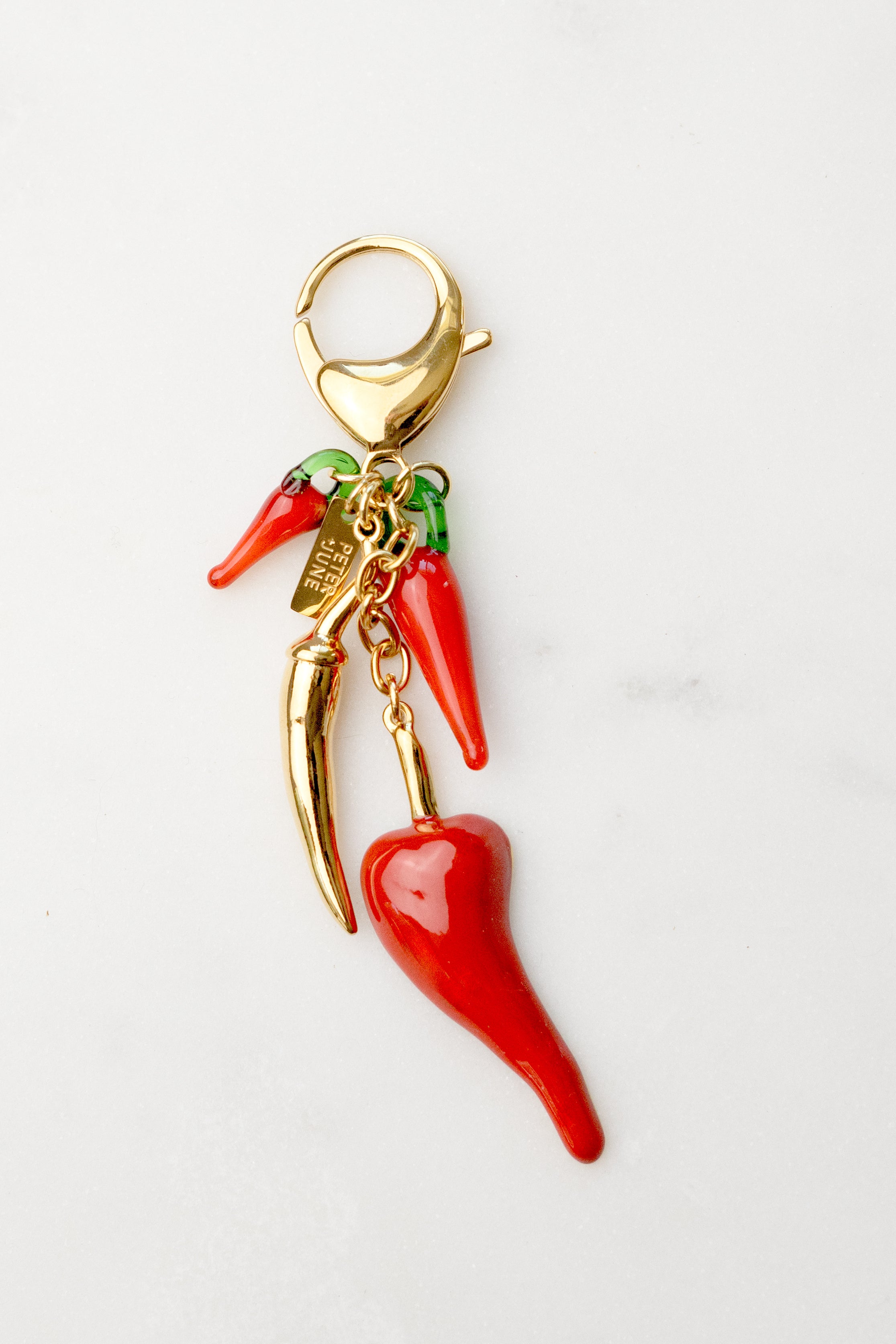 Red chili pepper charm with gold accents on a white background